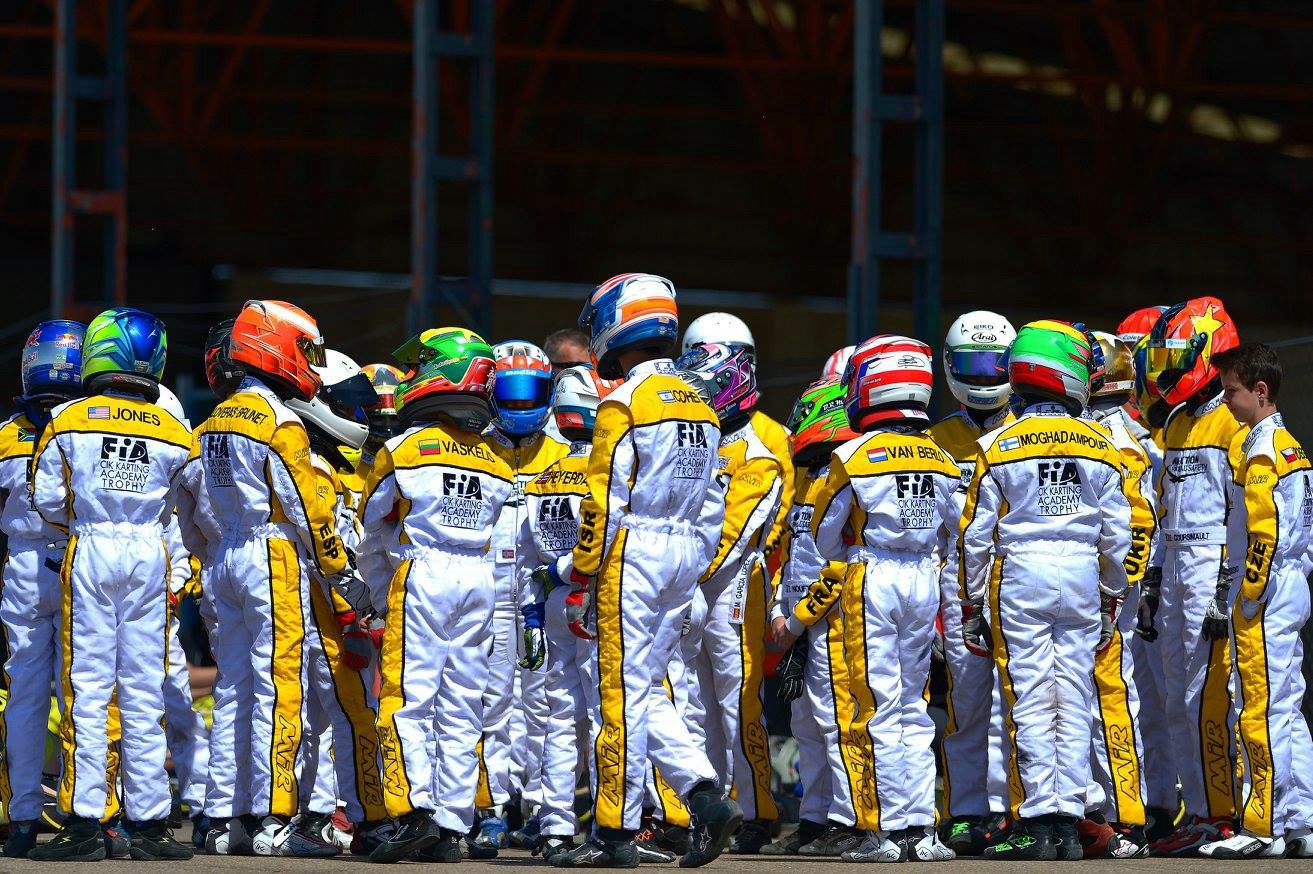 Drivers in CIK-FIA Karting Academy Trophy suits and helmets gathered before a race