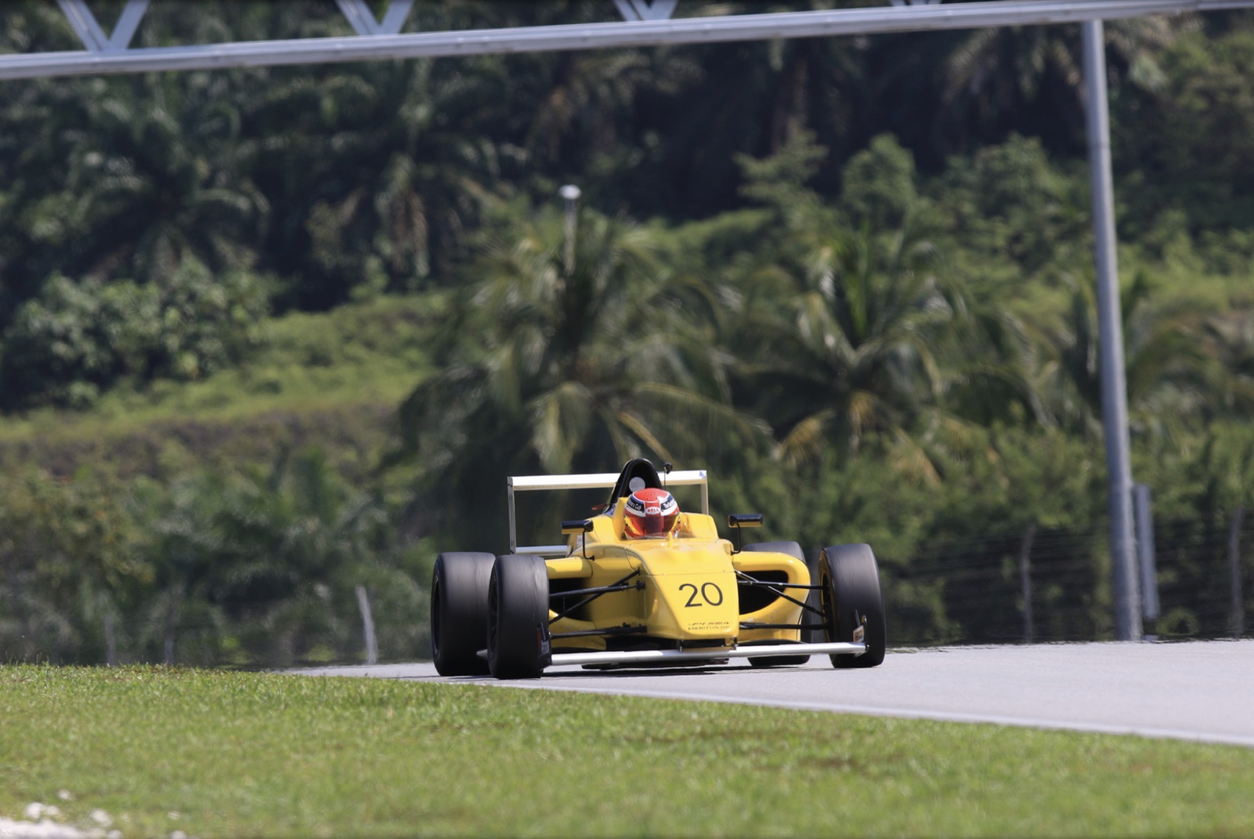 Yellow Formula 4 car under a gantry at Sepang