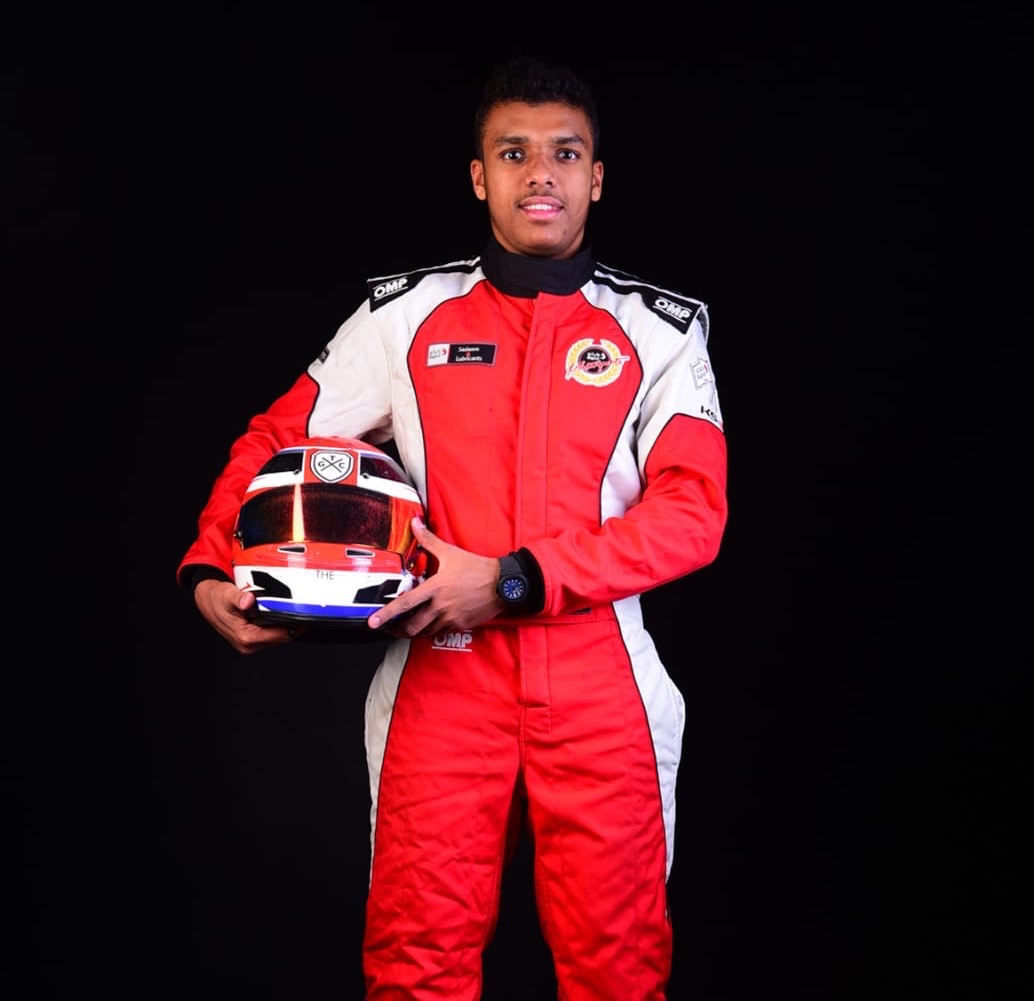 Talal Beshara in his red race suit holding his helmet